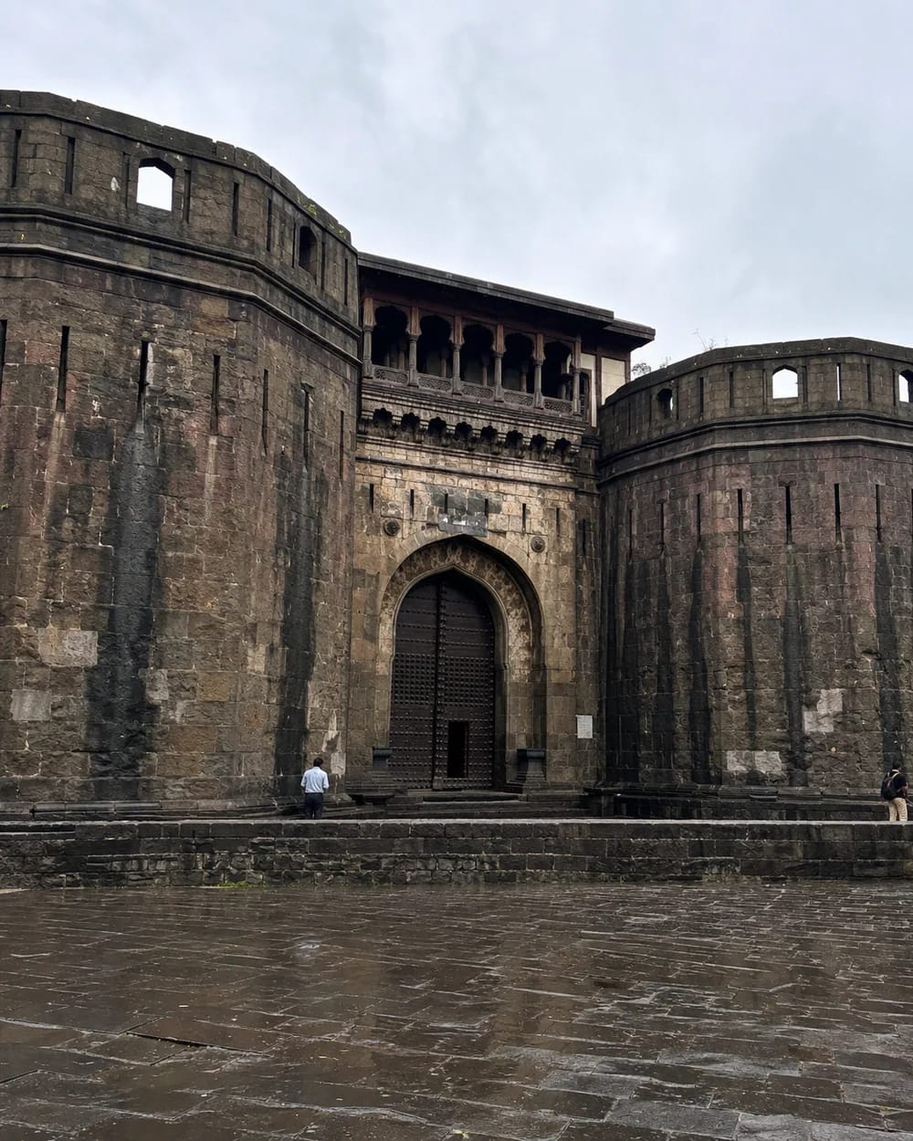 The rain-darkened Delhi Gate and basalt bastions of Shaniwar Wada in Pune