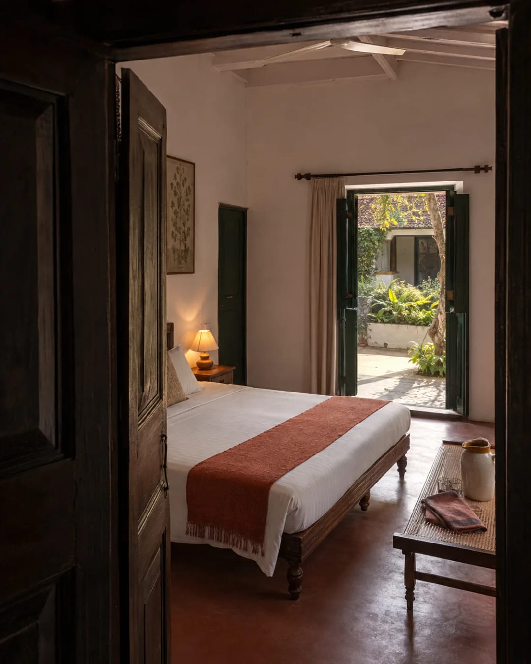 An arrival-ready bedroom opening onto a sunlit courtyard